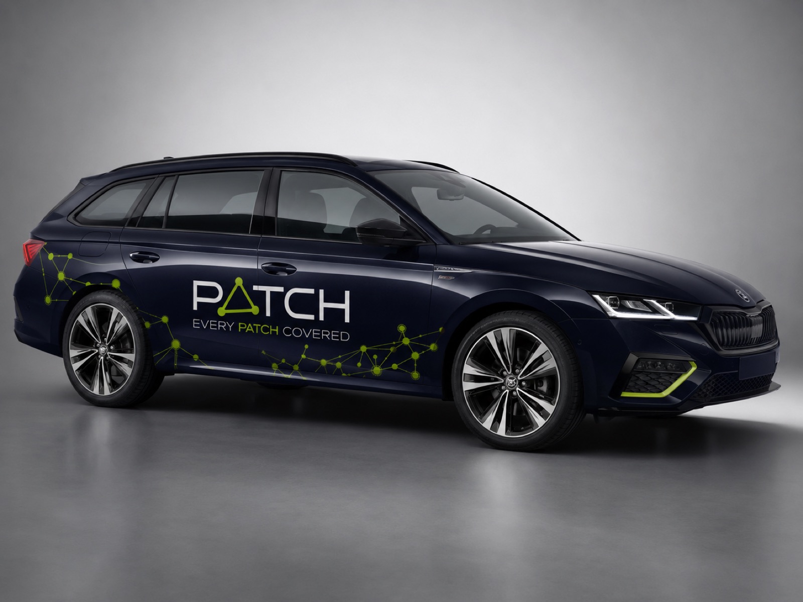 Estate car wrapped with the PATCH logo and a lime network along the doors